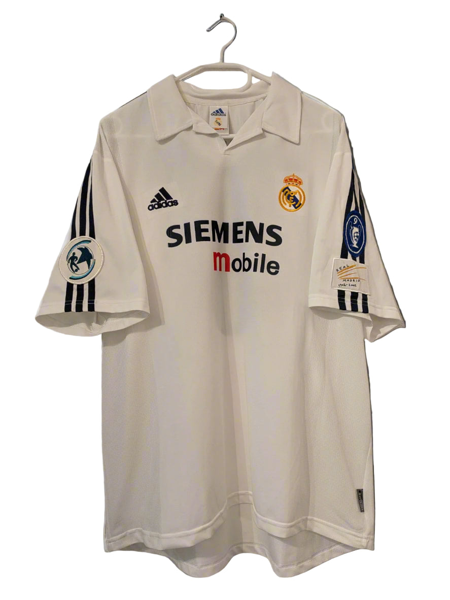 Real Madrid 2002/03 Home UCL Edition Jersey displayed on a hanger, predominantly white with sponsor logos and the Adidas logo.