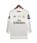 White soccer jersey with Adidas and Real Madrid logos on a hanger against a white background